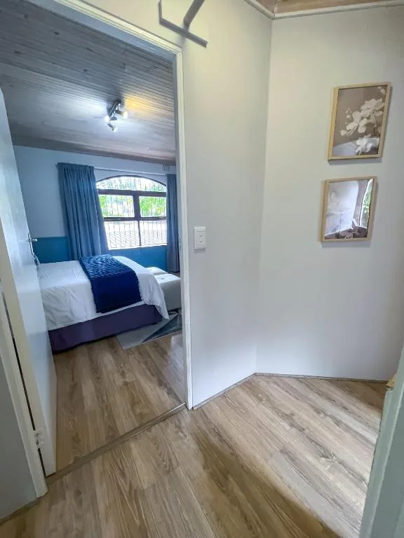 Modern bedroom with queen bed, blue accent pillows, and large window
