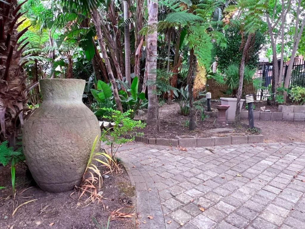 Lush garden courtyard with decorative stone urn and tropical plants