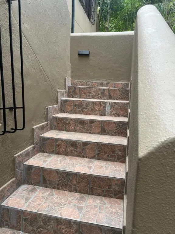 Outdoor stone steps leading up to property entrance with cream walls