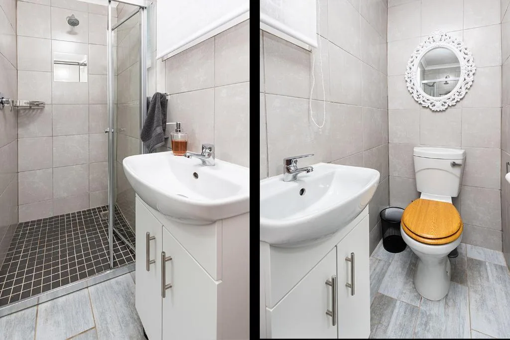 Modern bathroom with walk-in shower, dual vanities, and wooden toilet seat