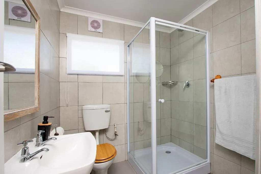 Modern bathroom with shower cubicle, vanity sink, and toilet fixtures