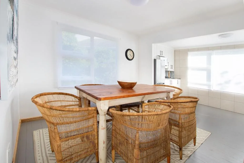 Bright dining area with wooden table and woven rattan chairs
