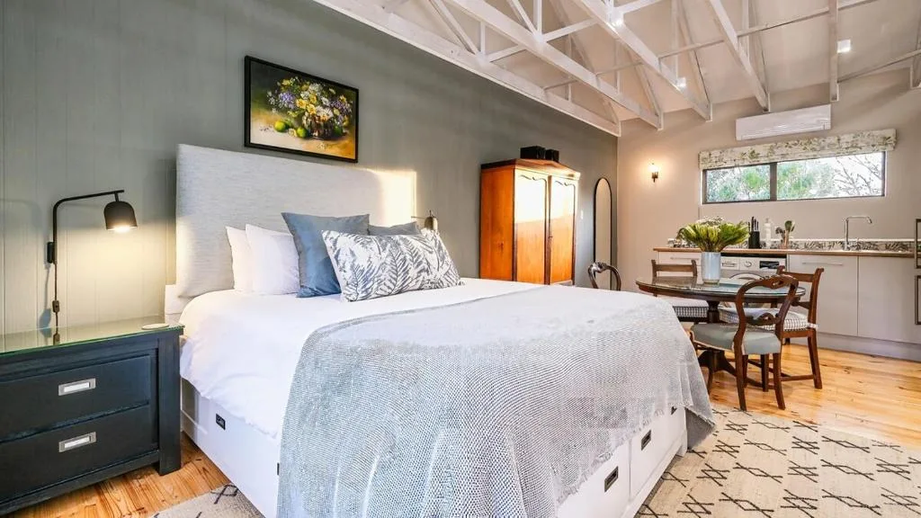 Spacious bedroom with queen bed, modern lighting, and workspace area