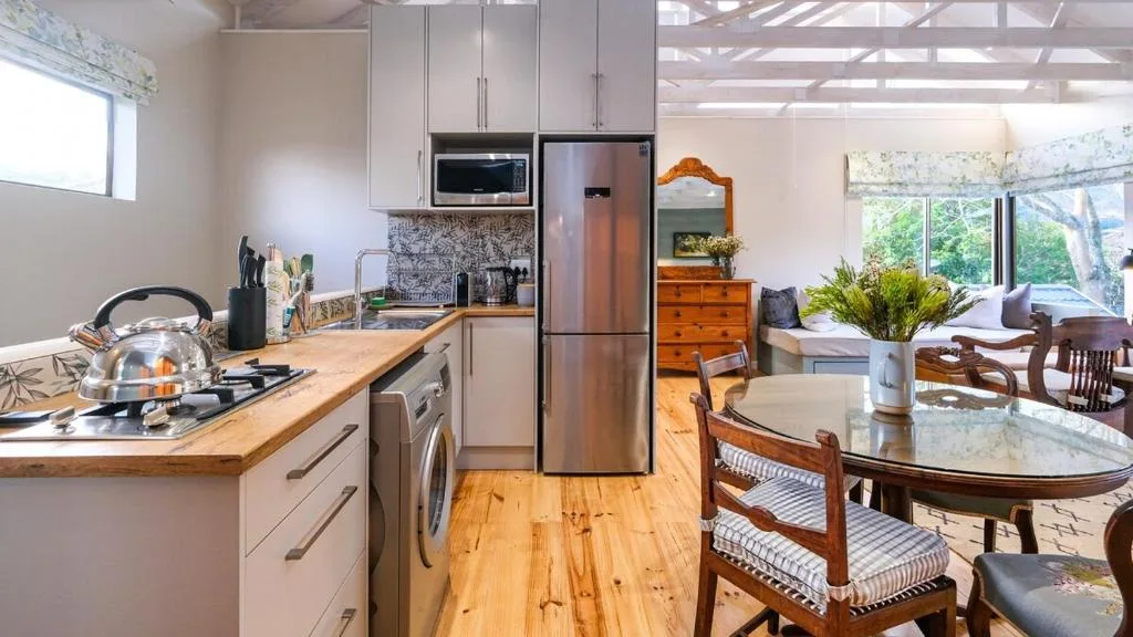 Modern kitchen with stainless steel appliances and wooden dining area
