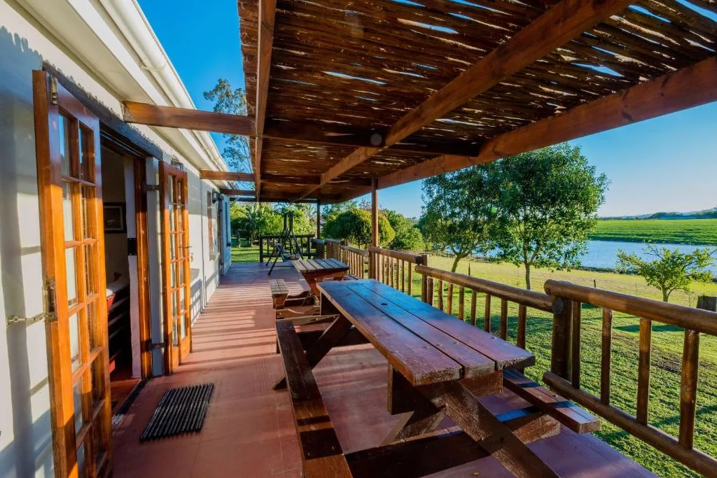 Wooden deck with picnic table overlooking lagoon and green fields