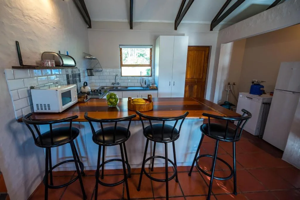Modern farmstay kitchen with wooden counter seating and stainless steel appliances