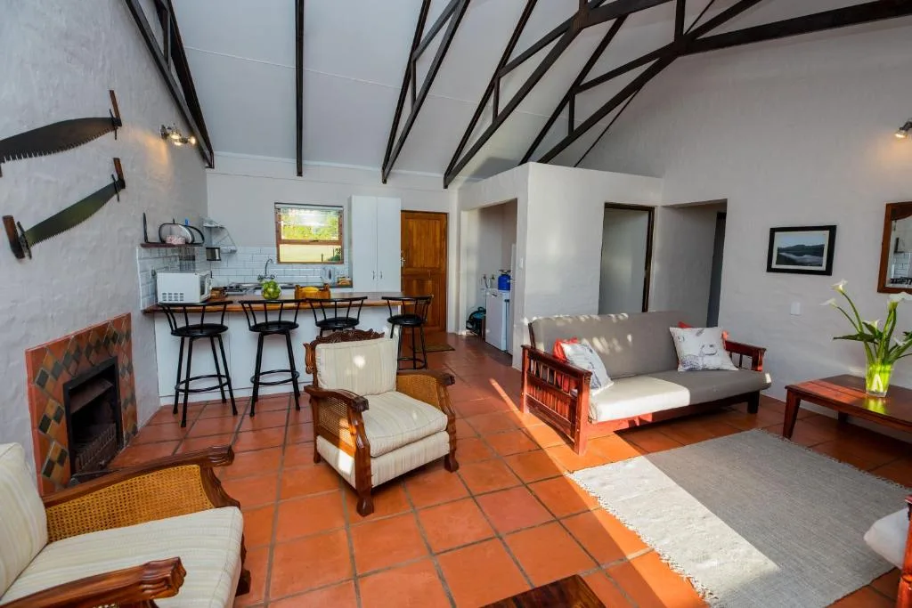 Open-plan lounge with sofa, armchair, fireplace, and kitchen counter seating