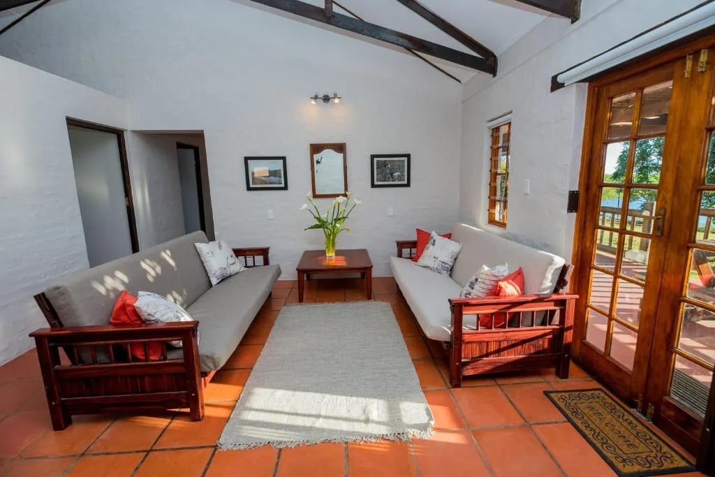 Spacious lounge with two sofas, wooden furniture, and terracotta floors