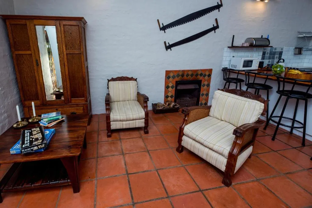 Spacious lounge with striped armchairs, fireplace, and wooden furniture
