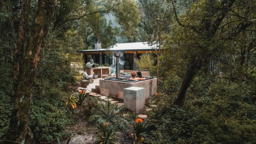 Boshuis Farm Stay — outdoor braai deck under tall trees, George