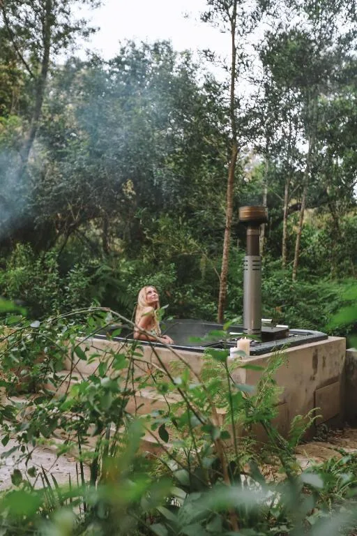 Outdoor braai area nestled among tall trees in lush garden setting