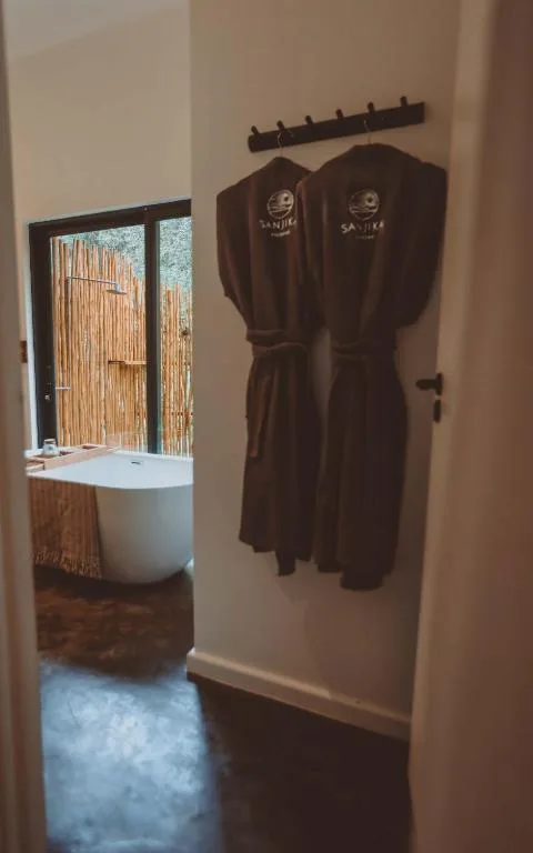 Two brown robes hanging on wall near bathroom entrance