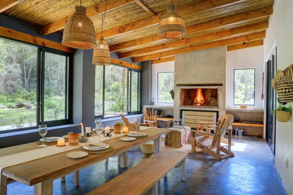 Rustic dining room with wooden table, fireplace, exposed beams, pendant lights