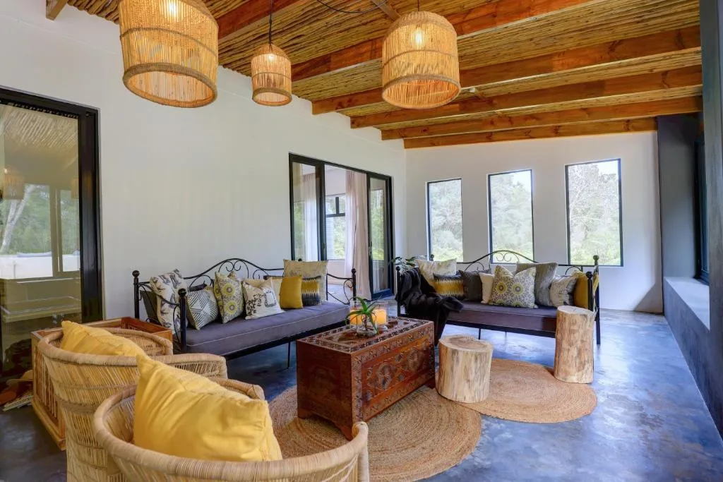 Bright lounge with woven pendant lights, metal-frame sofas, and yellow accent chairs