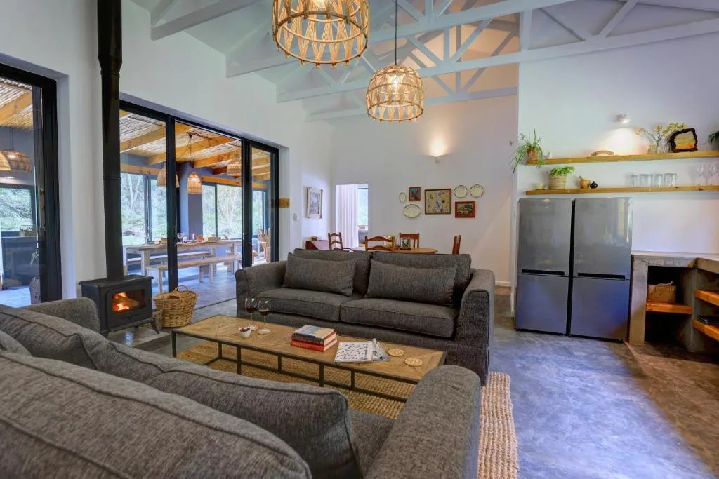 Modern lounge with gray sofas, wood fireplace, and pendant lighting