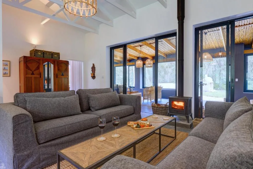 Spacious lounge with gray sofas, wood-burning stove, and large sliding doors
