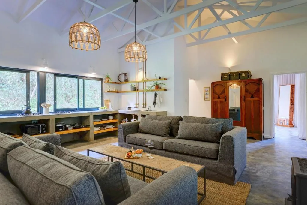 Modern lounge with gray sofas, woven pendant lights, and open kitchen