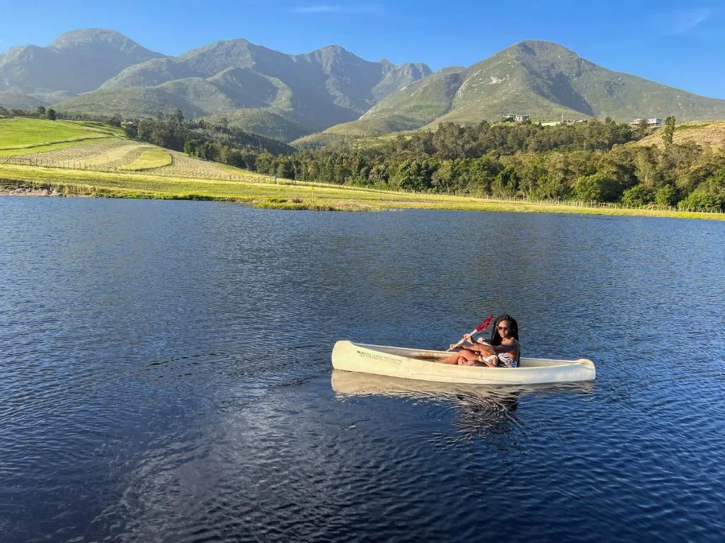 Mountain lake with dramatic peaks and green valleys under clear blue sky