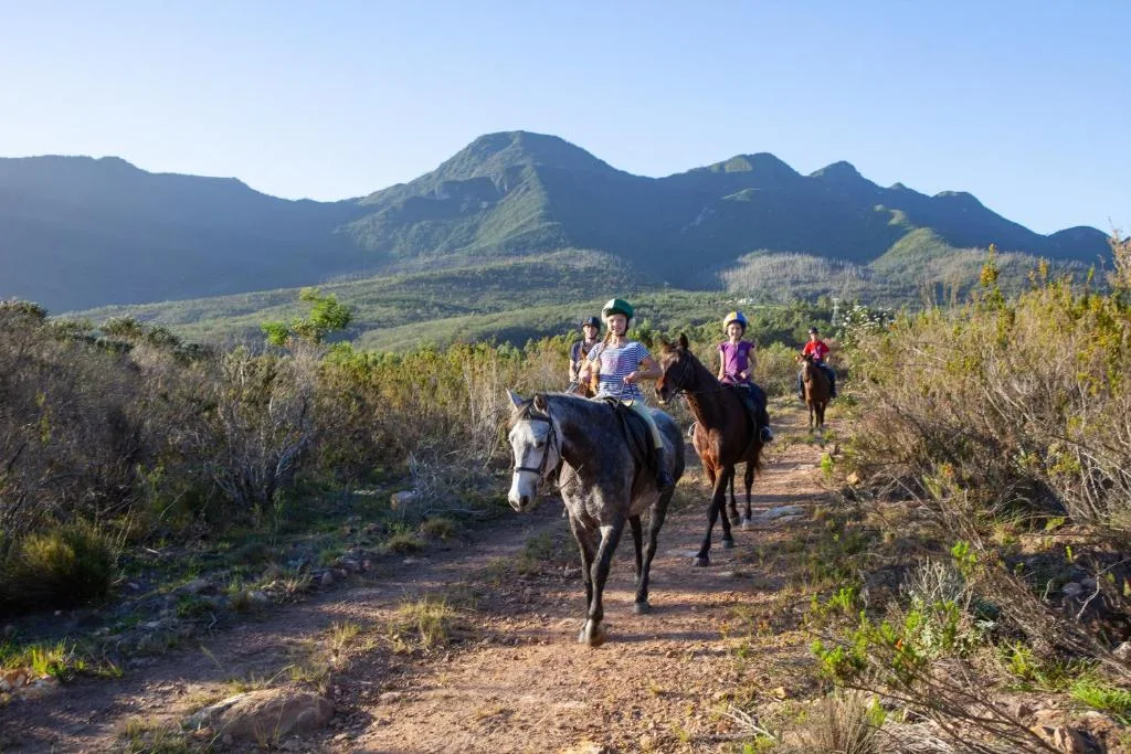 Majestic mountain landscape with riders on horseback on scenic trail