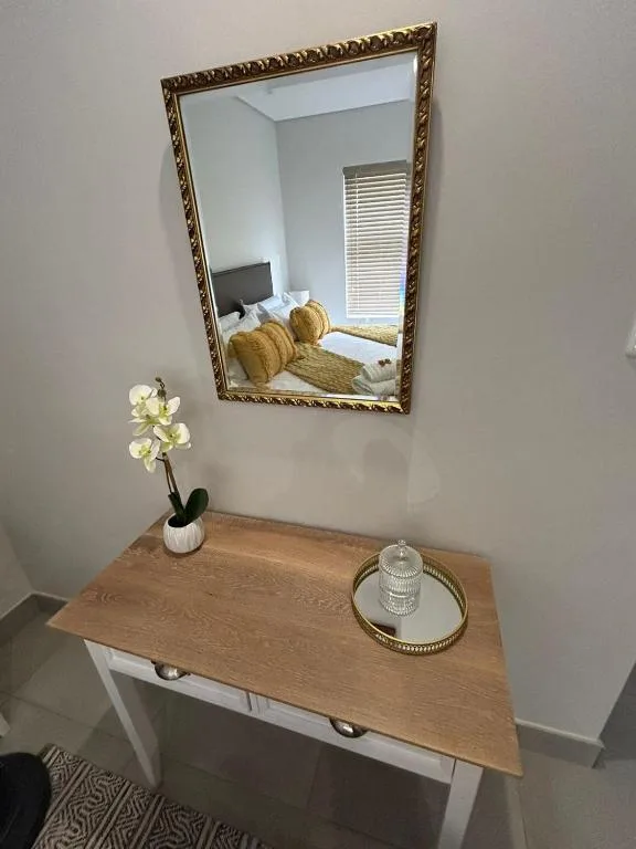 Elegant vanity mirror with wooden console table and decorative accents