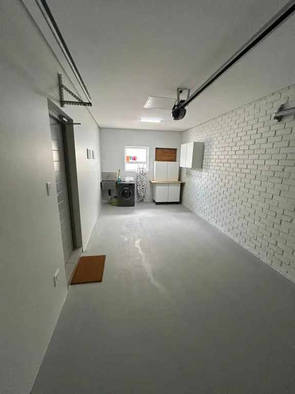 Modern laundry room with white brick wall and concrete flooring