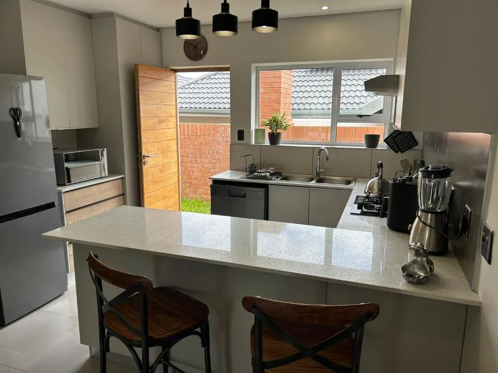 Modern kitchen with island countertop, stainless steel appliances, and pendant lighting