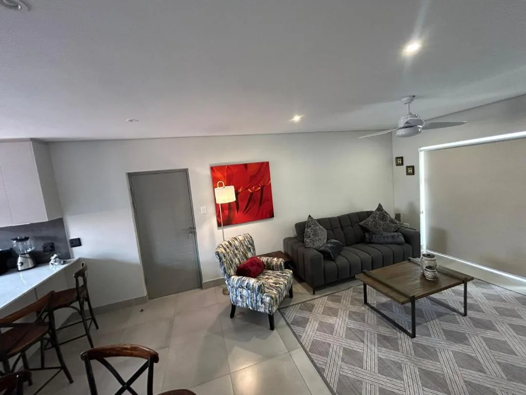Modern living room with black sofa, patterned armchair, and wooden coffee table