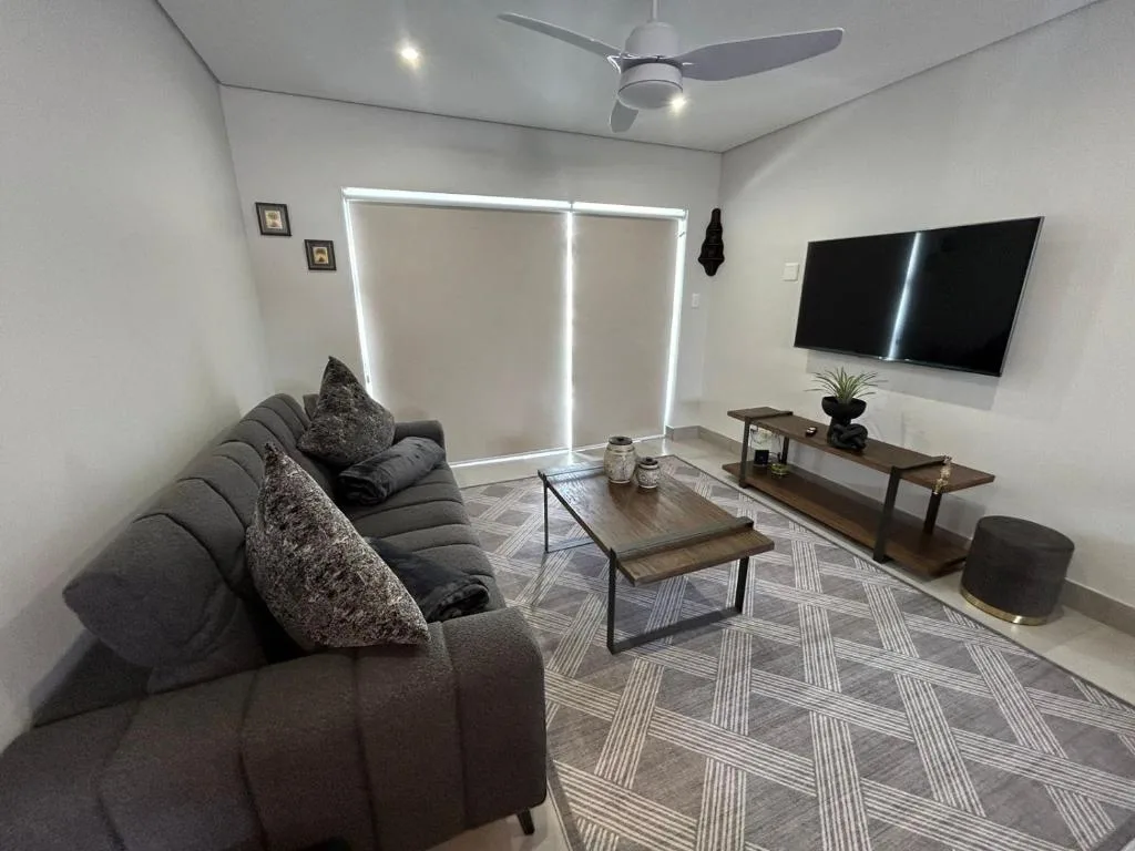 Modern living room with gray sofa, wall-mounted TV, and coffee table