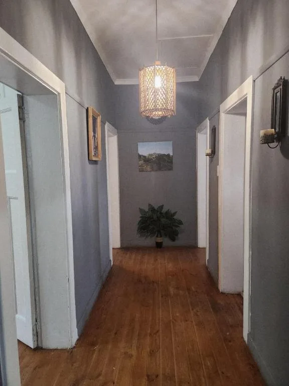 Modern hallway with purple walls, wooden floors, pendant lighting fixture