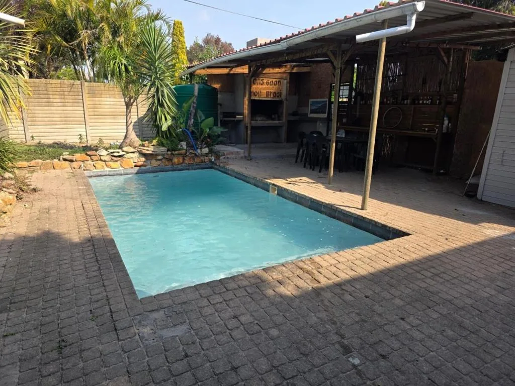 Rectangular swimming pool with turquoise water and brick patio surround