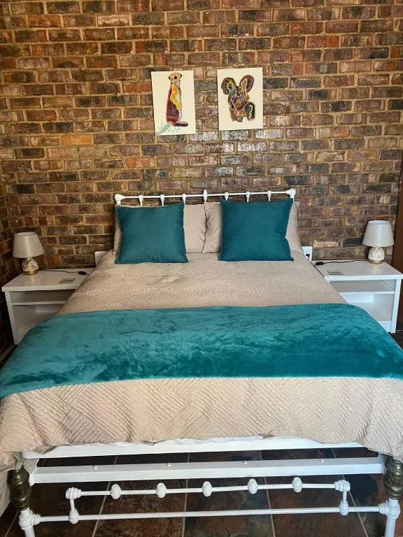 Bedroom with teal accents, brick wall, and contemporary bedside tables