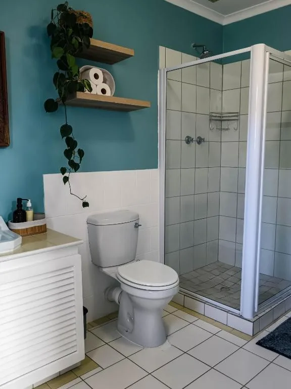 Modern bathroom with toilet, vanity, and glass-enclosed shower stall