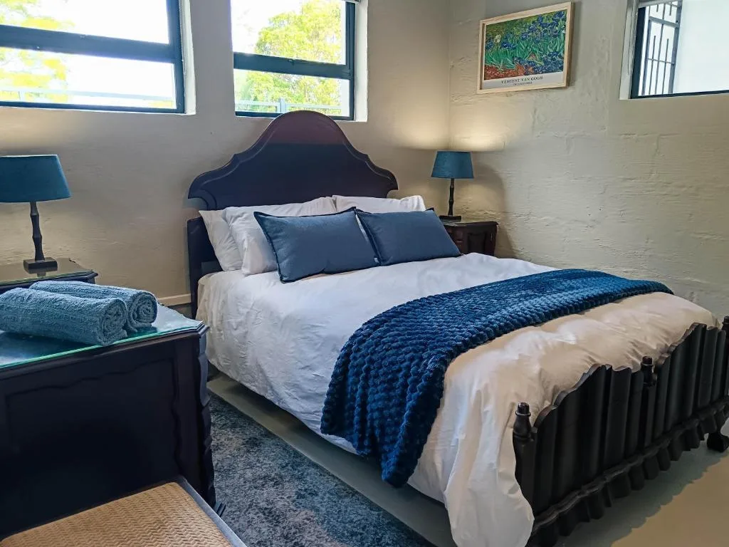 Spacious bedroom with dark iron bed frame and blue bedding accents