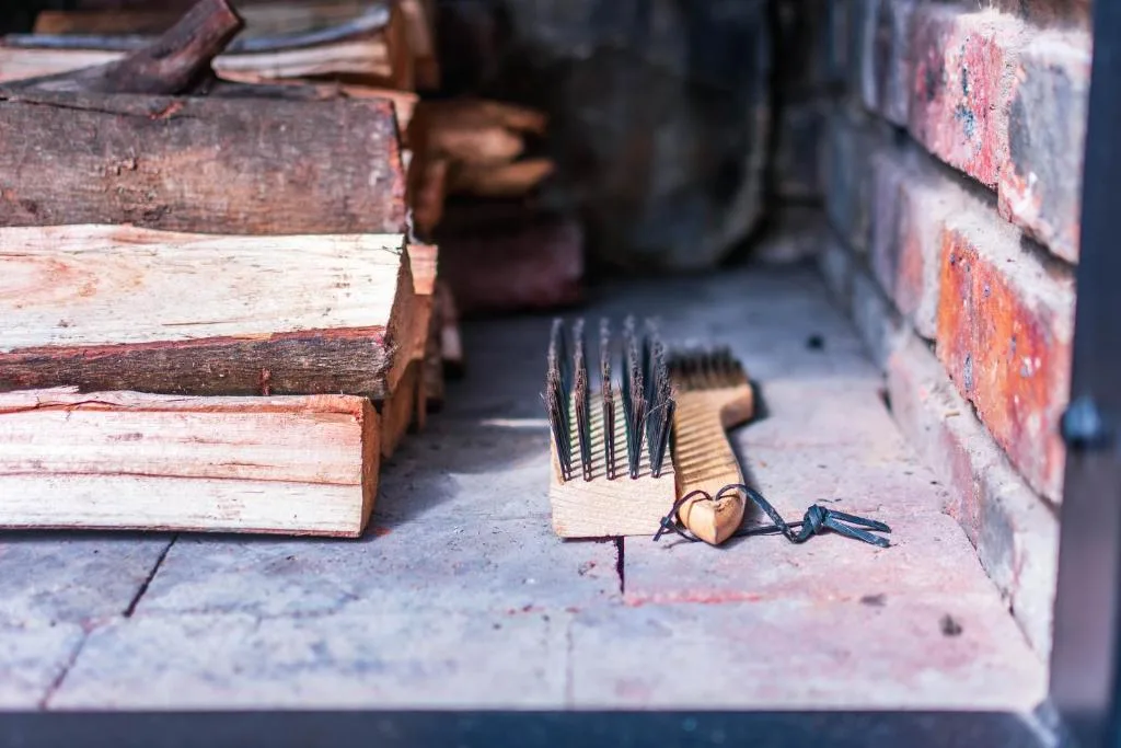 Close-up of traditional braai tools and wooden logs on outdoor surface