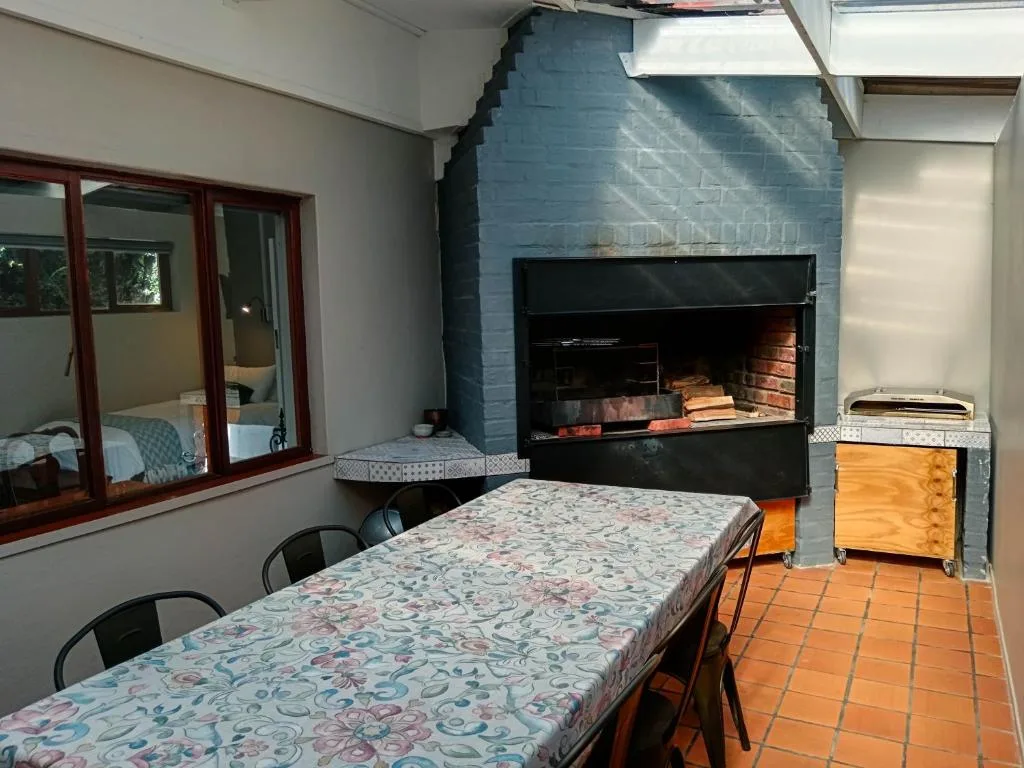 Dining table with patterned tablecloth and fireplace in background