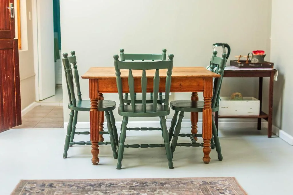 Wooden dining table with green chairs in bright dining area