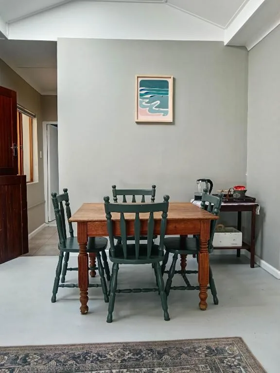 Spacious dining area with wooden table and green chairs