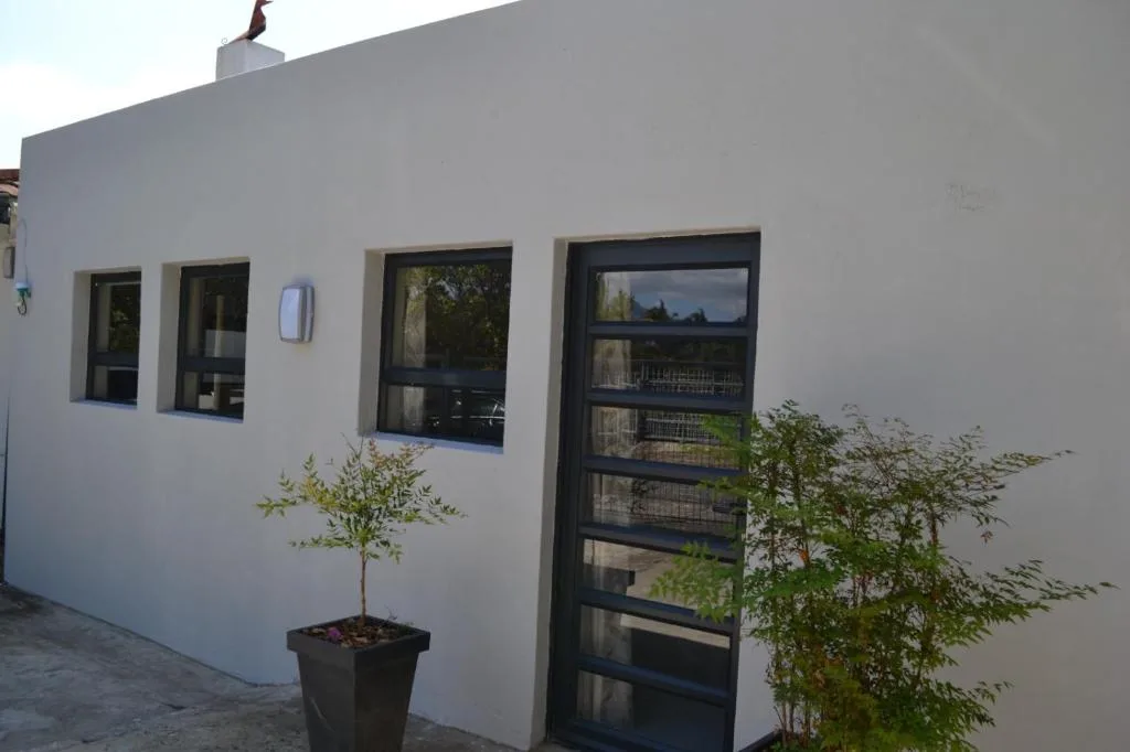 Modern white apartment facade with black-framed windows and entrance door