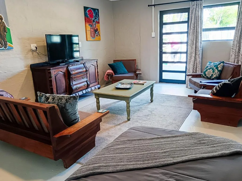 Living room with wooden furniture, TV, coffee table, and garden views