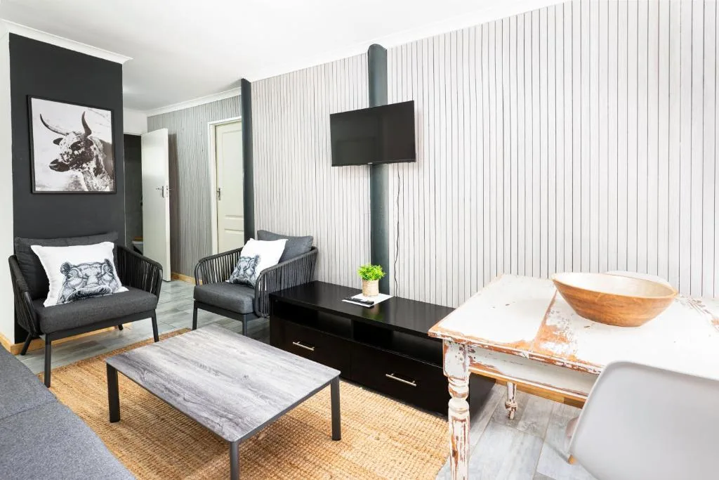 Modern lounge with black accent wall, comfortable seating, and flat-screen TV