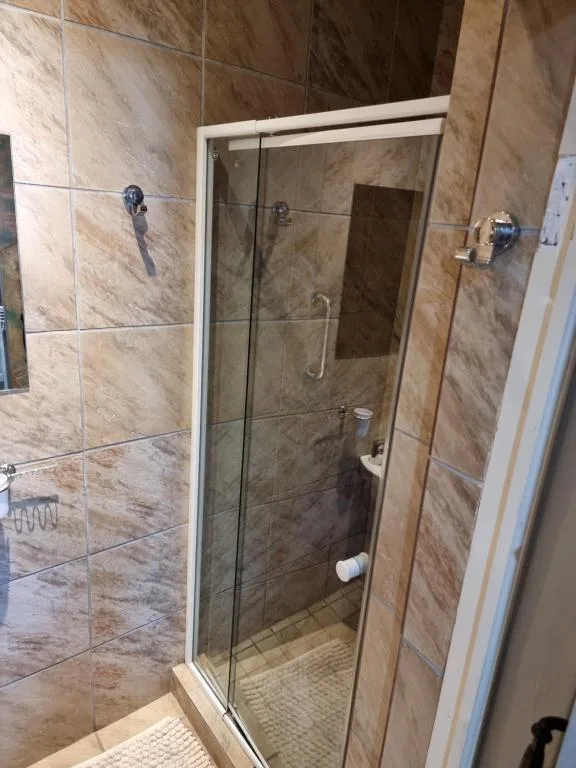 Modern walk-in shower with glass enclosure and marble tile walls
