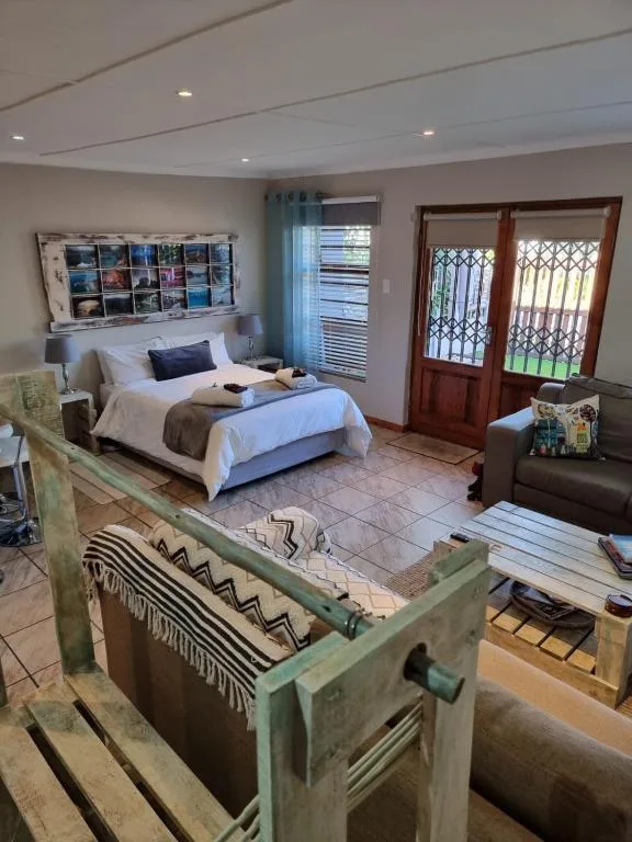 Spacious bedroom with double bed, seating area, and garden doors