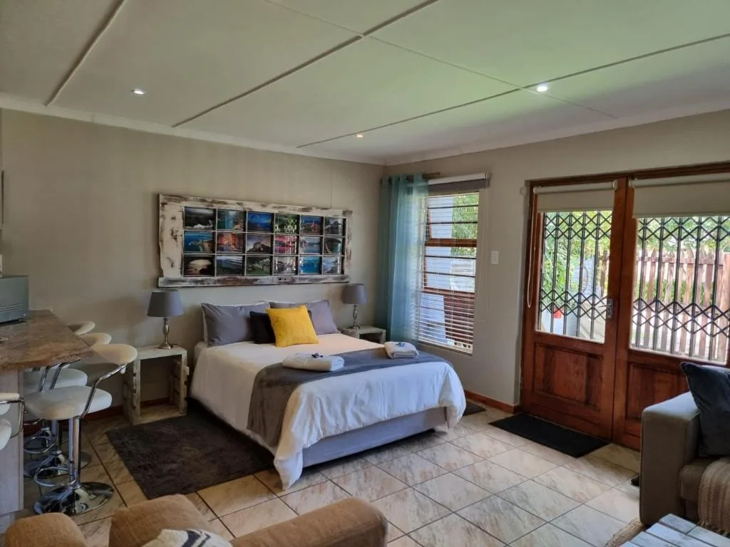 Spacious bedroom with queen bed, work desk, and glass doors opening outdoors