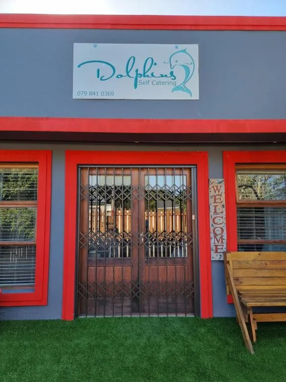 Colorful red and blue apartment entrance with dolphin logo sign above