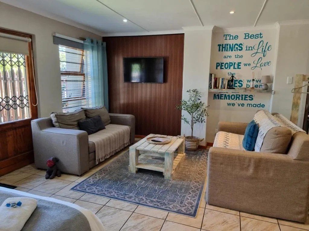 Modern living room with comfortable seating, wall-mounted TV, inspirational wall art