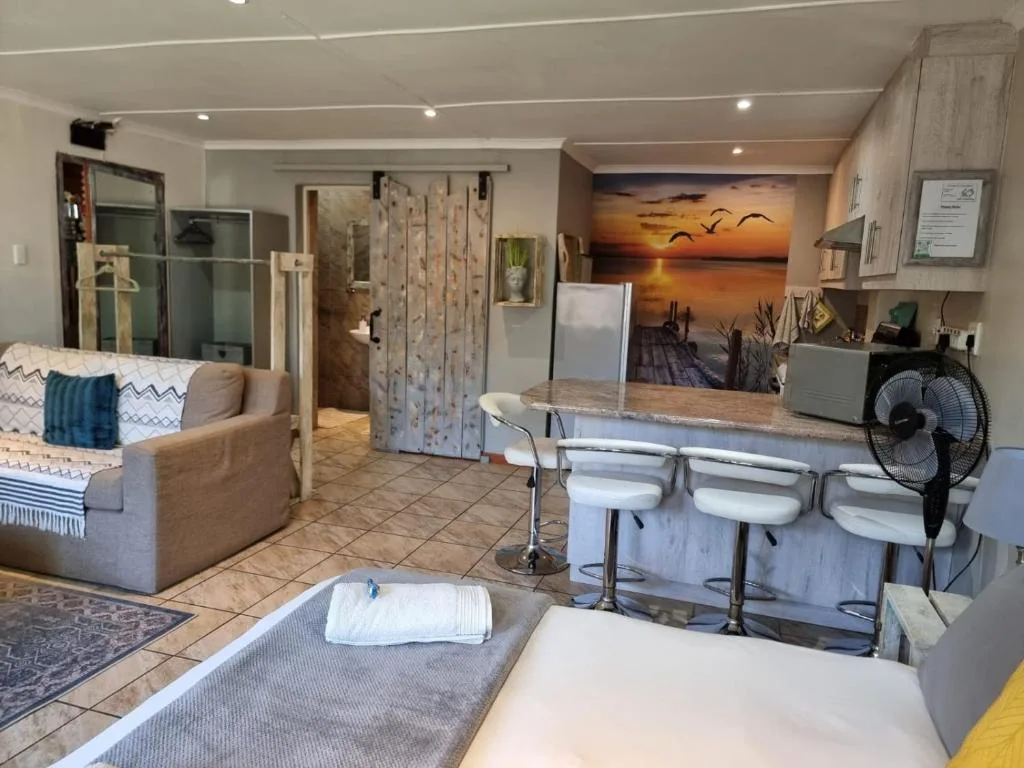 Open-plan living area with comfortable seating and kitchen counter in background