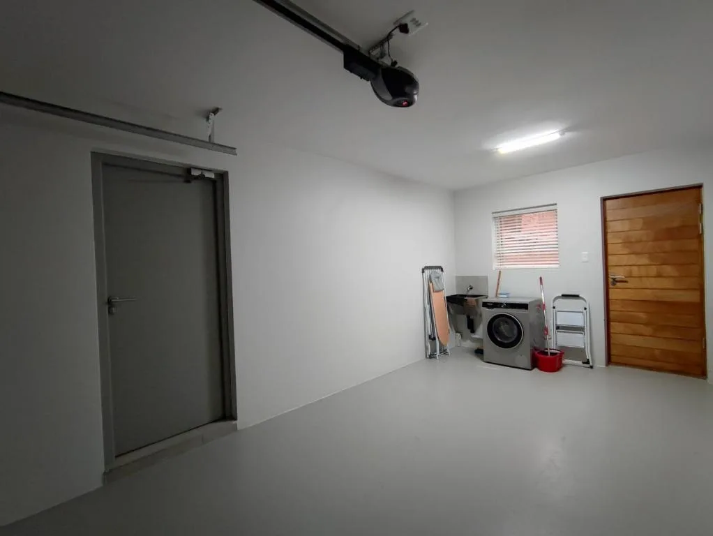 Laundry room with washing machine, storage, and utility items