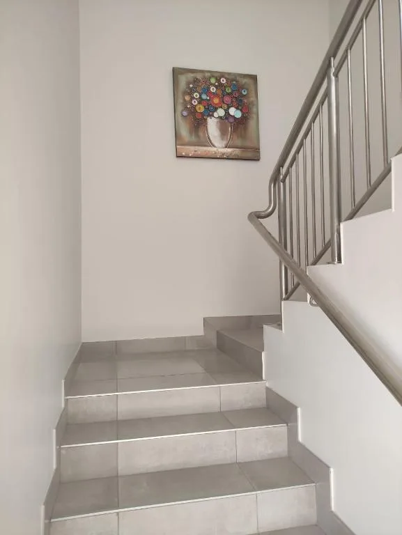 Modern staircase with metal railing and floral artwork on wall