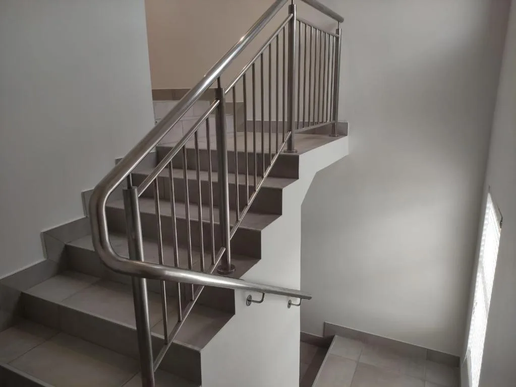 Modern staircase with stainless steel railings and dark steps