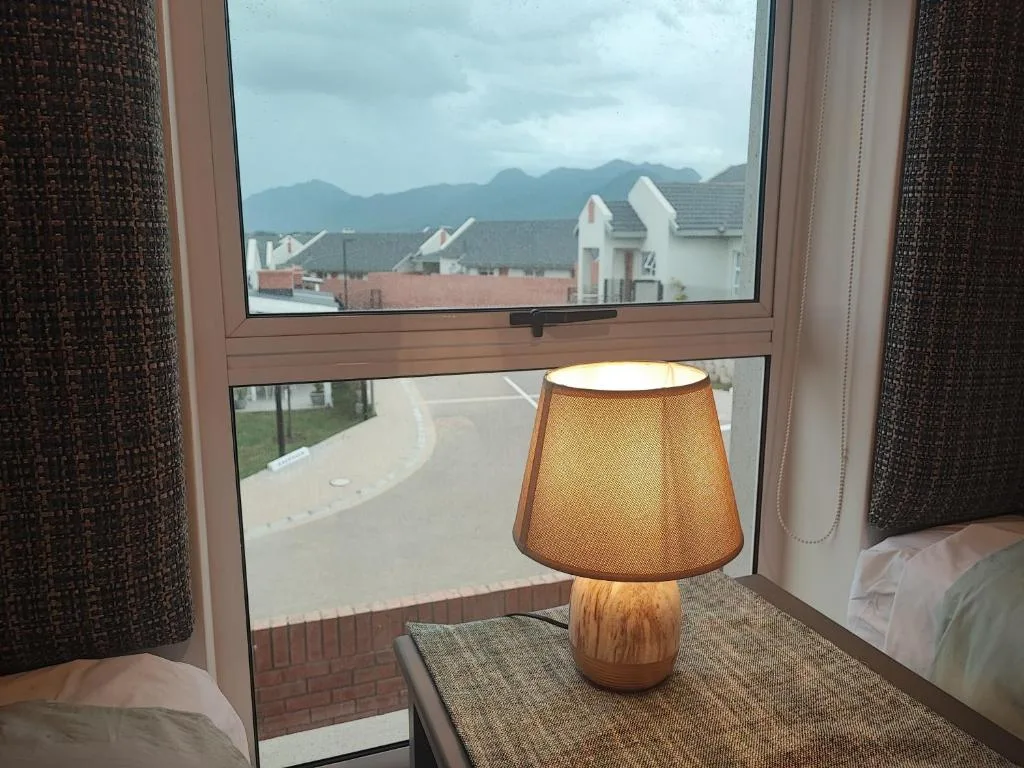 Mountain landscape visible through bedroom window with local architecture